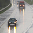 cars driving down wet highway with light rain